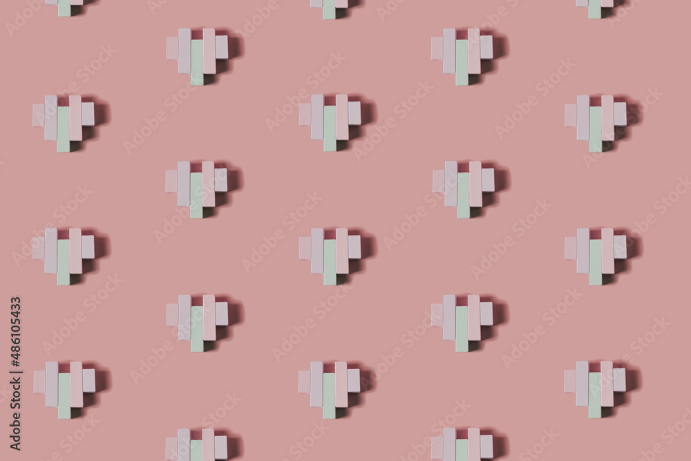 Creative pattern made of wooden block heart shapes. Love visual with pastel colors. Minimal flat lay background.