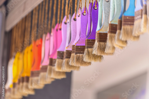 Lots of colorful brushes hang on ropes from the ceiling in front of the shop. © Marina Gordejeva
