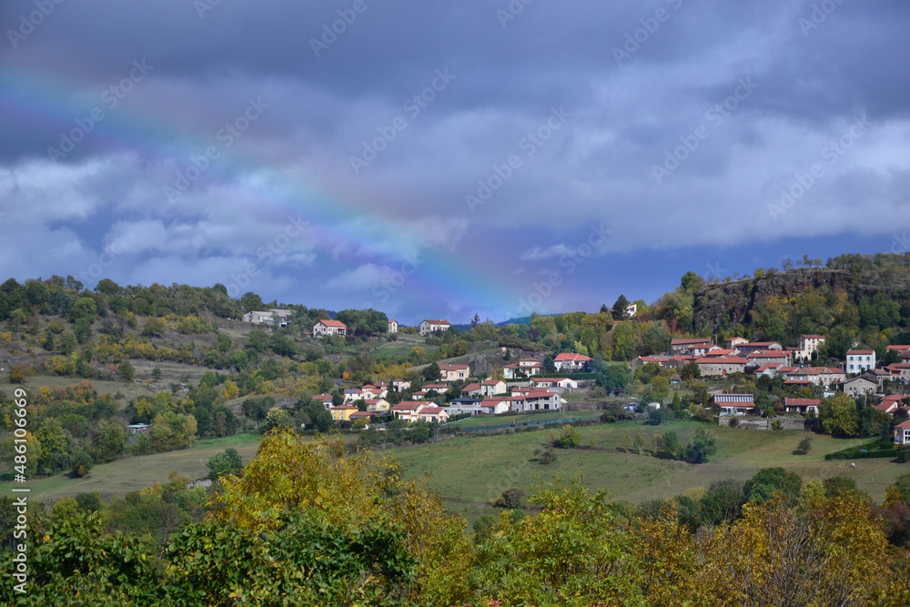 Very nice landscape in Auvergne, close to small french villages. It's near the city of Le Puy-en-Velay, during summer. You can see an hamlet with a rainbow.