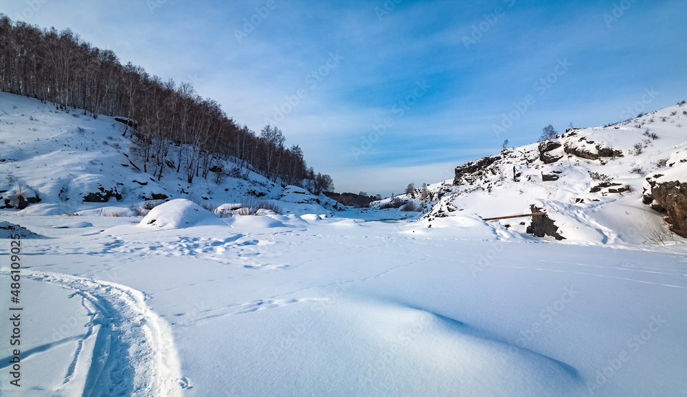 Winter landscape with trees and sky from the high rocky river bank