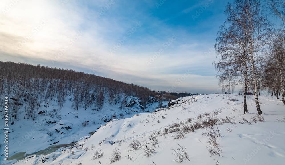 Winter landscape with trees and sky from the high rocky river bank Winter landscape with trees and sky from the high rocky river bank