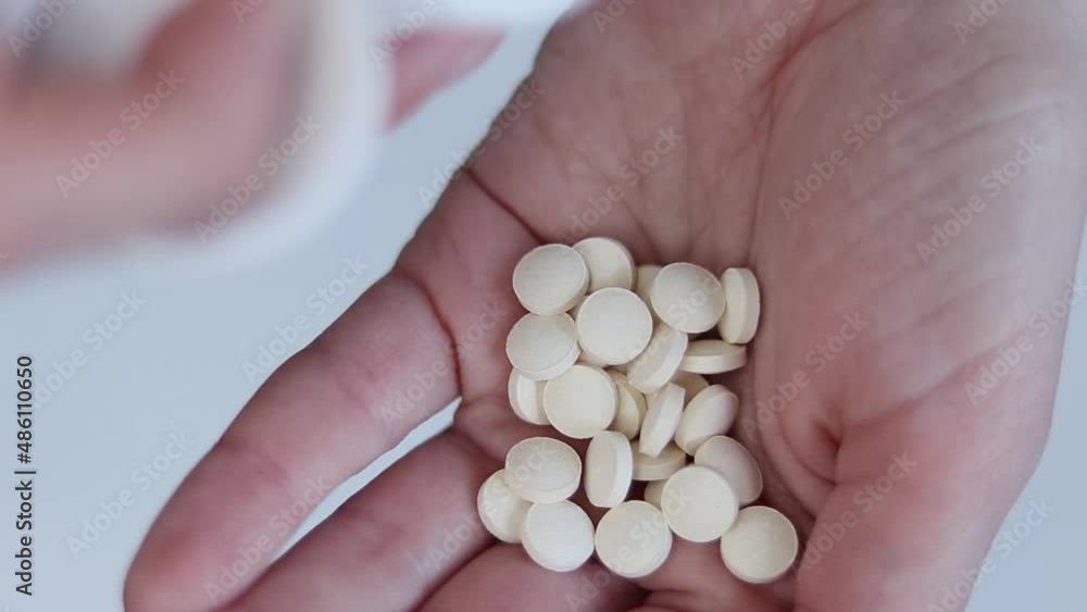 A woman pours zinc tablets into her hand. Pills close-up. Healthy concept. A woman pours zinc tablets into her hand. Pills close-up. Healthy concept.