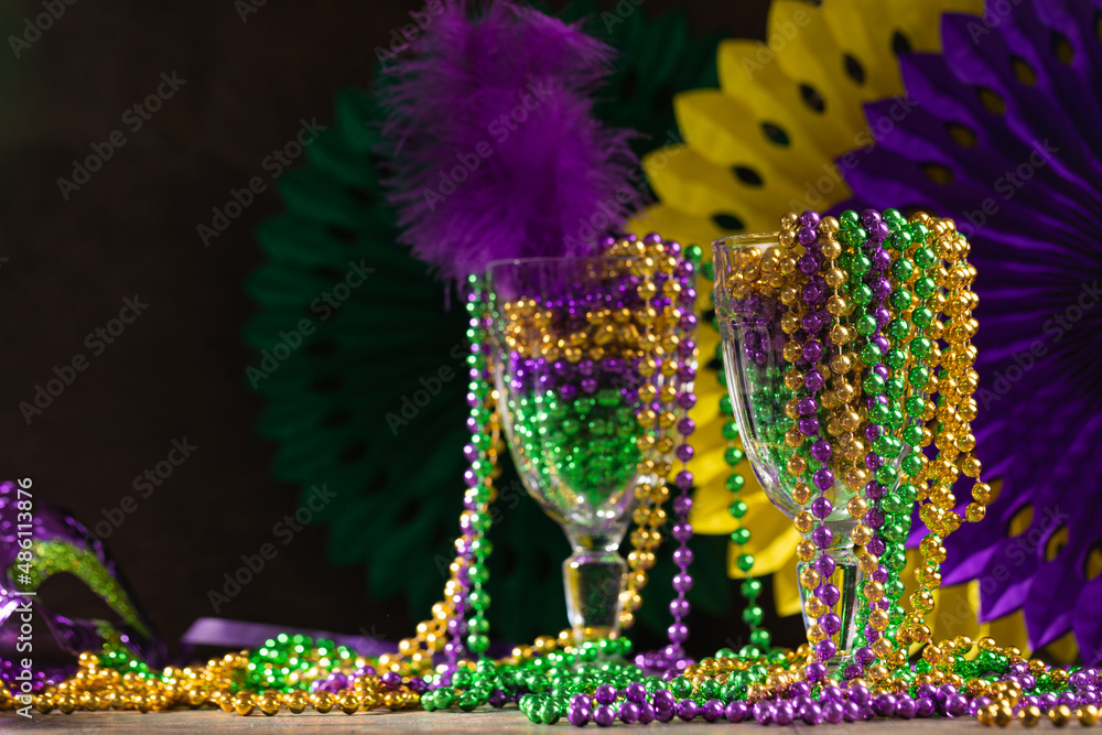 Mardi gras carnivale mask, green, purple, yellow beads on rustic tile background - obrazy, fototapety, plakaty 