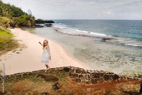 A girl in a white dress on the Gris-Gris beach on the island of Mauritius photo