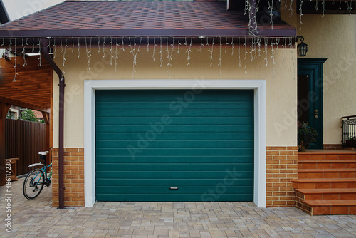 Garage Door. A garage with blue doors at the end of a driveway