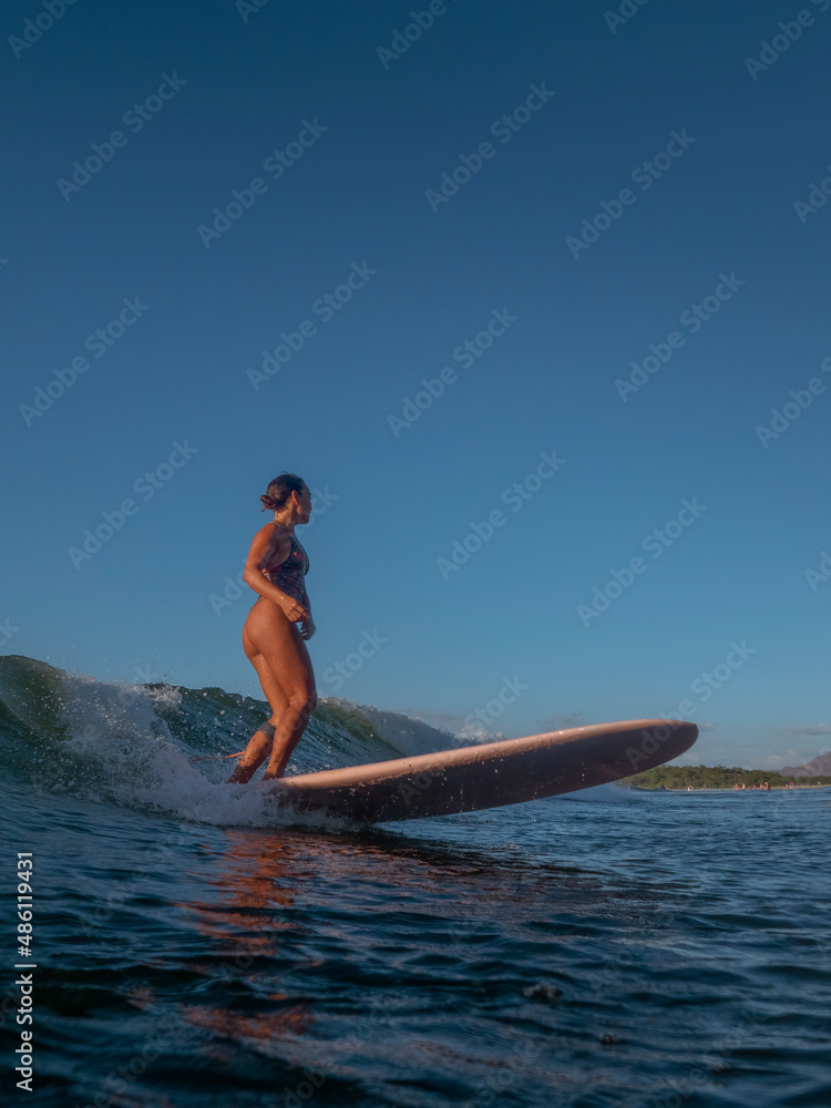 Girl Surfing on her longboard