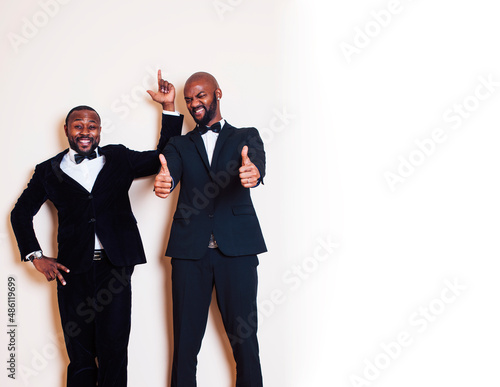 two african-american businessmen in black suits emotional posing, gesturing, smiling. wearing bow-ties photo