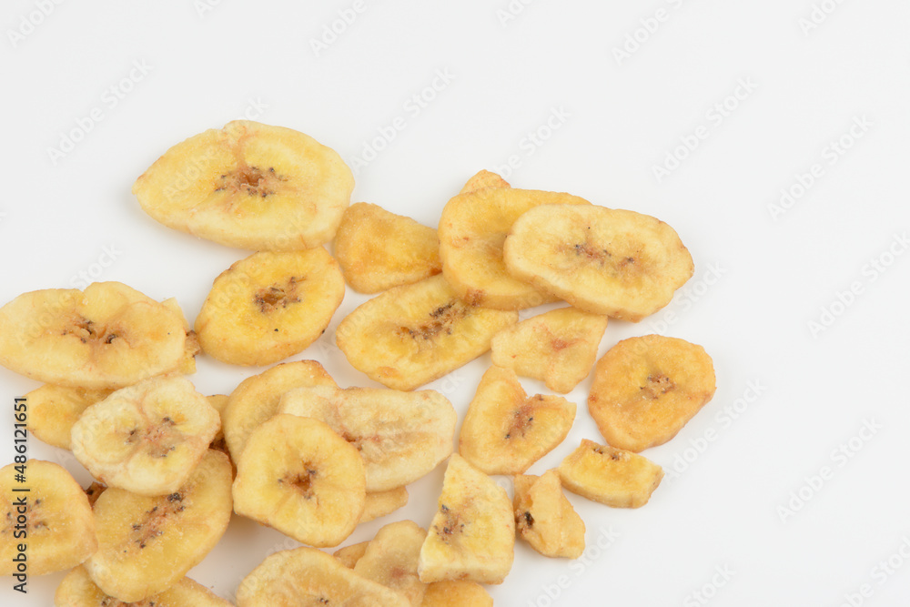 Banana deshidratada cortada en rodajas sobre fondo blanco