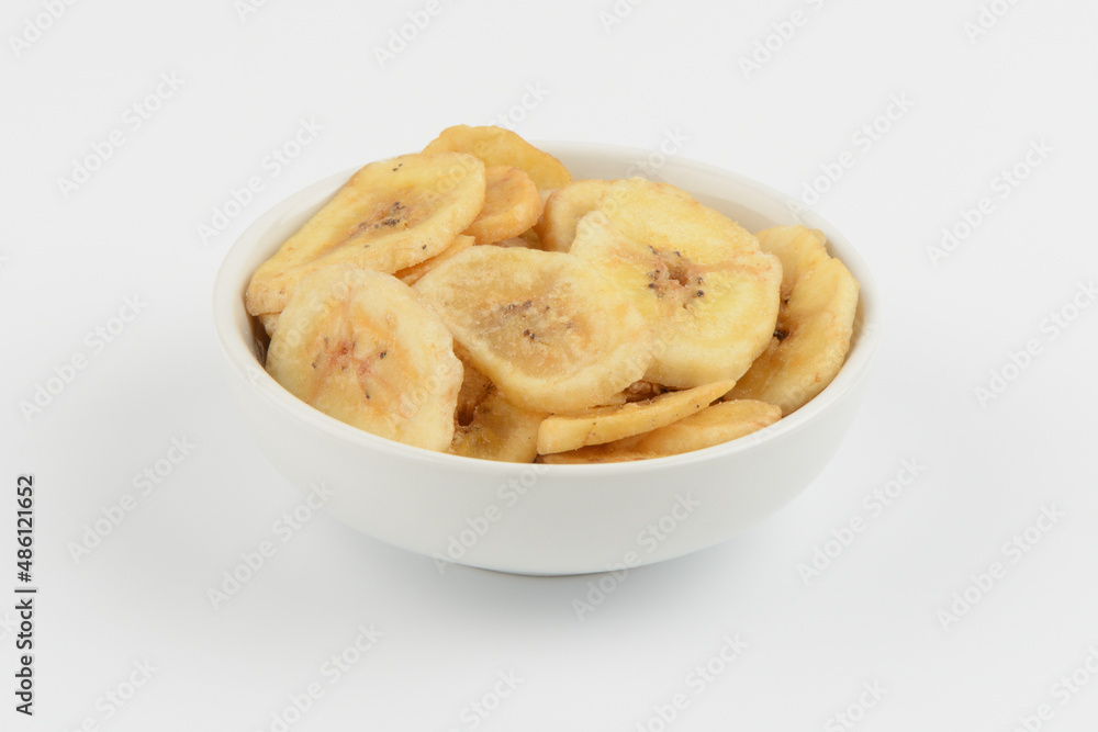 Banana deshidratada en un bol de cerámica blanca sobre fondo blanco