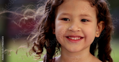 Happy little girl child smiling to camera with joy