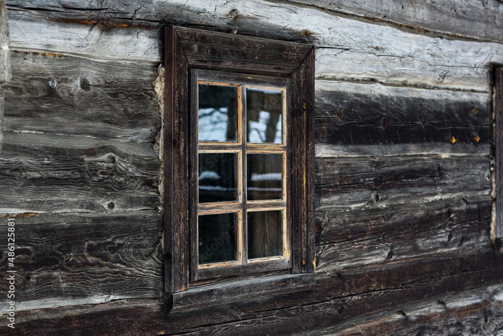Rustic wooden house made of round logs. Abandoned villages and houses. Ancient window design. Wooden window frame. Snow covered village. Age-old buildings. Professional photography. Rustic wooden house made of round logs. Abandoned villages and houses. Ancient window design. Wooden window frame. Snow covered village. Age-old buildings. Professional photography.