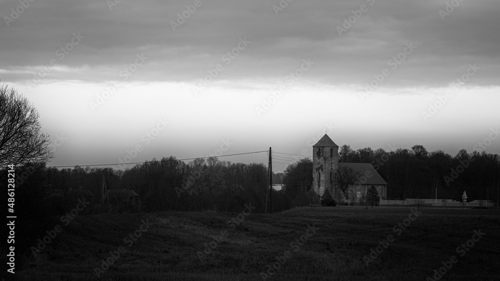 dark gloomy landscape with old church in Latvia countryside. Lestene church