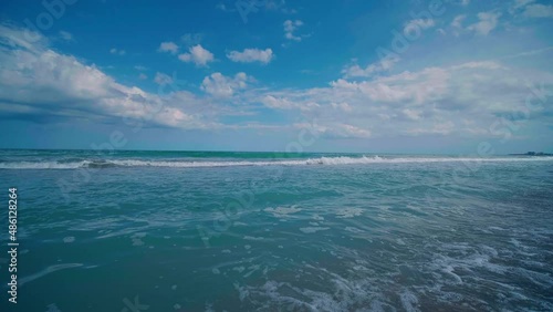 Beach sunny day, blue sky. Beautiful seascape. White foamywaves and white sand in the daytime. View of Black sea seachore. photo