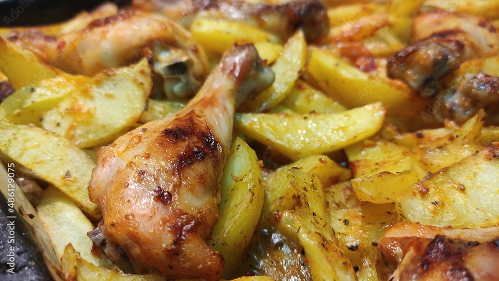 Fried potatoes with chicken legs close-up. Food background.