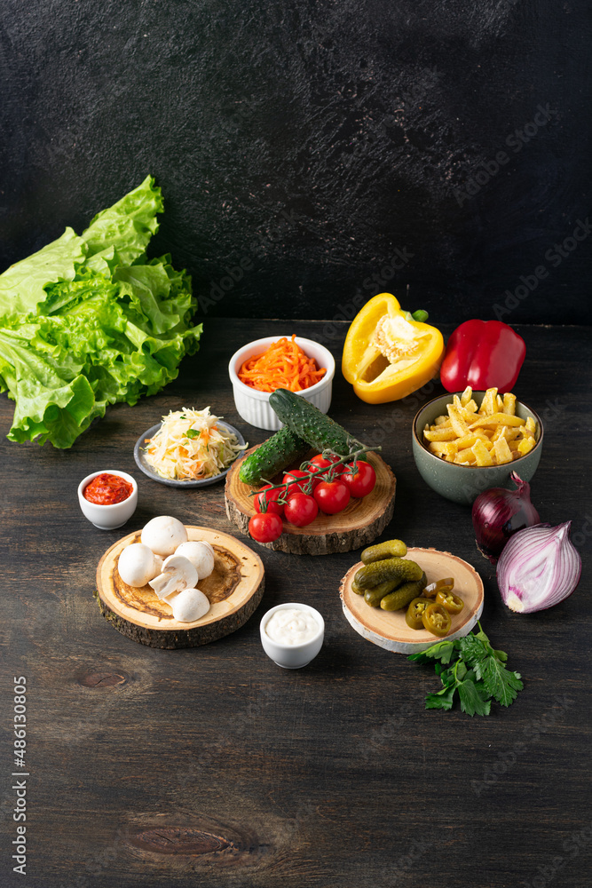 Ingredients for Shawama sandwich with spices and sauces on dark background. Vertical