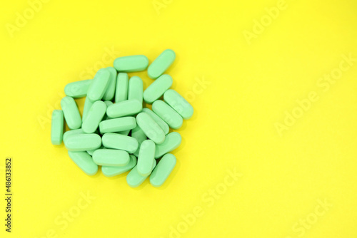 Green pills on a bright yellow background 