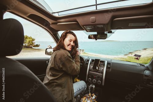 woman sitting in car relaxed and looking at sea beach