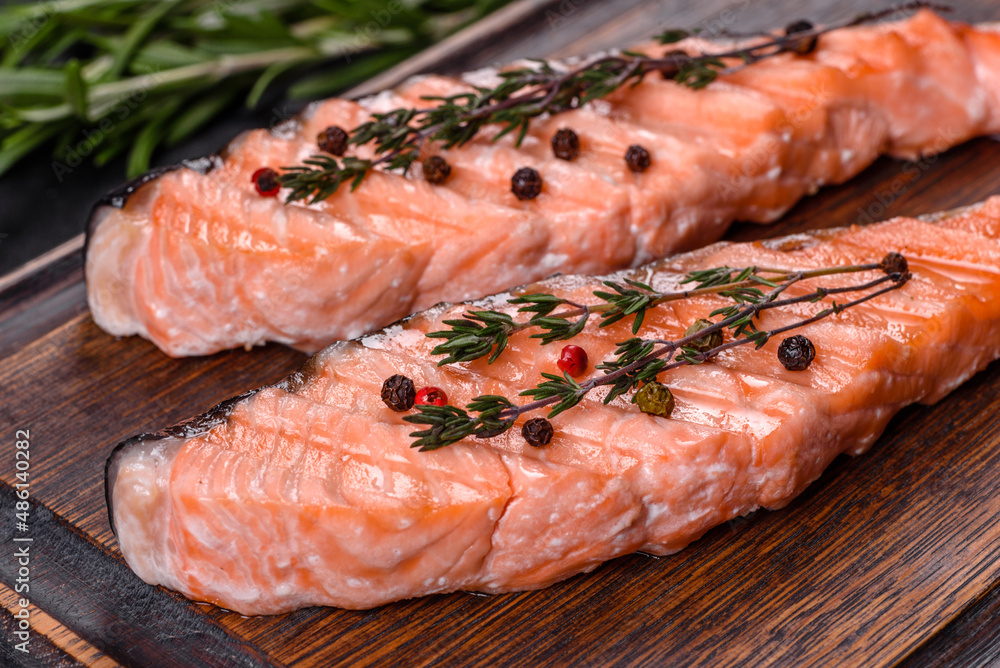 Grilled salmon with herbs served on black concrete table Grilled salmon with herbs served on black concrete table
