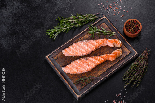 Grilled salmon with herbs served on black concrete table