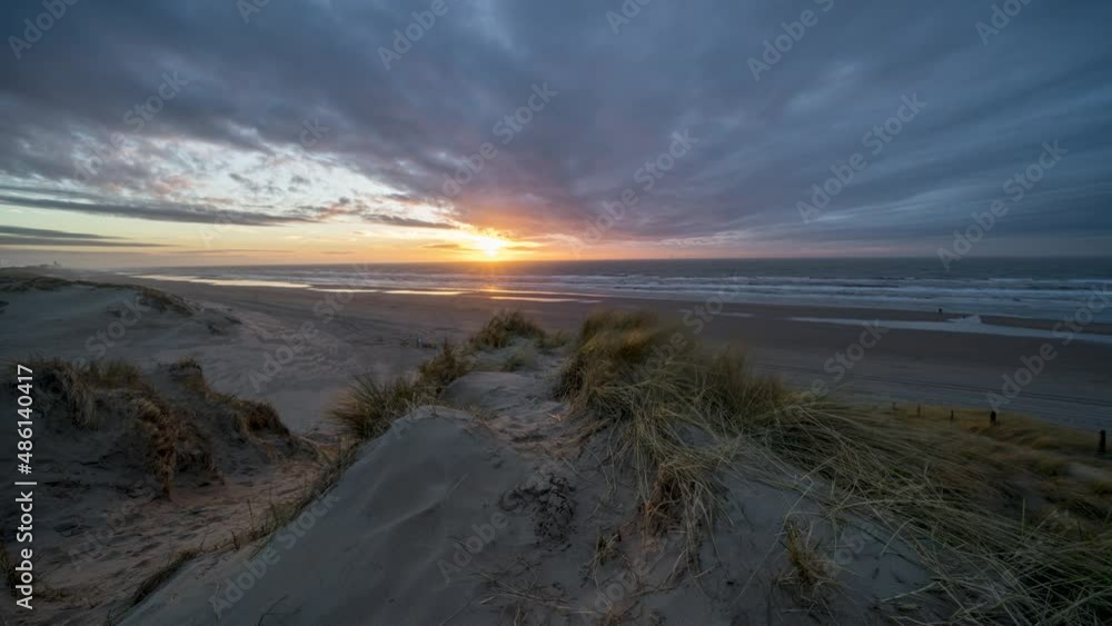 4k timelapse of stunning sunset on Dutch North sea coast with sand dunes and colouring clouds 4k timelapse of stunning sunset on Dutch North sea coast with sand dunes and colouring clouds