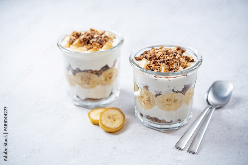 Banana Greek yogurt chocolate granola parfait in a glass Banana Greek yogurt chocolate granola parfait in a glass