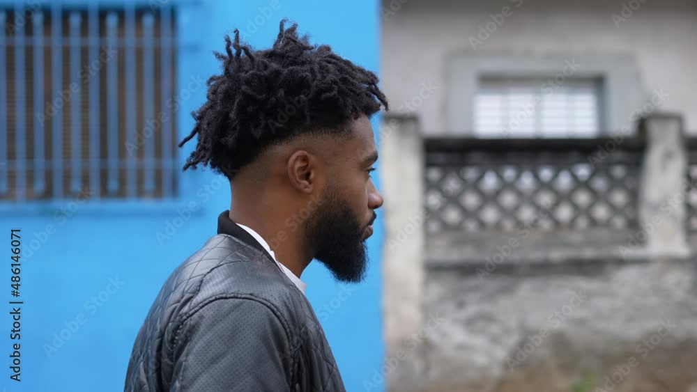 A pensive person walking outside in street one Brazilian man walks forward A pensive person walking outside in street one Brazilian man walks forward