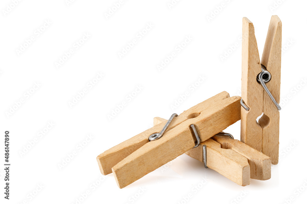Three wooden clothespins, isolated on a white background, lie together. Close-up photo. Full depth of field.