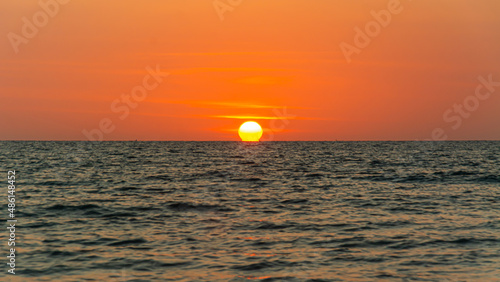 Fototapeta Naklejka Na Ścianę i Meble -  Bright sunset with large yellow sun under the sea surface