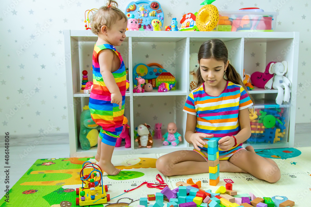 Children play together in the playroom. Selective focus. Children play together in the playroom. Selective focus.