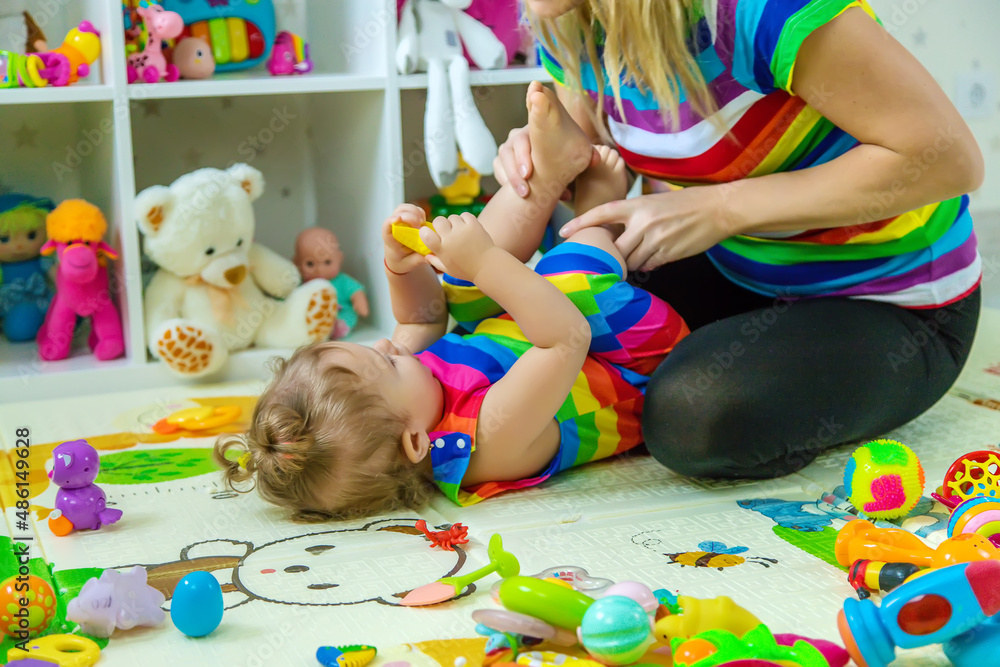 Fototapeta premium Baby plays in the room with her mother. Selective focus.