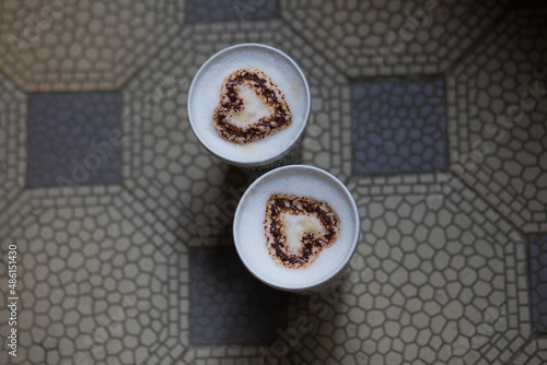 Cute romantic cup of coffee with dark chocolate on retro tile floor from above