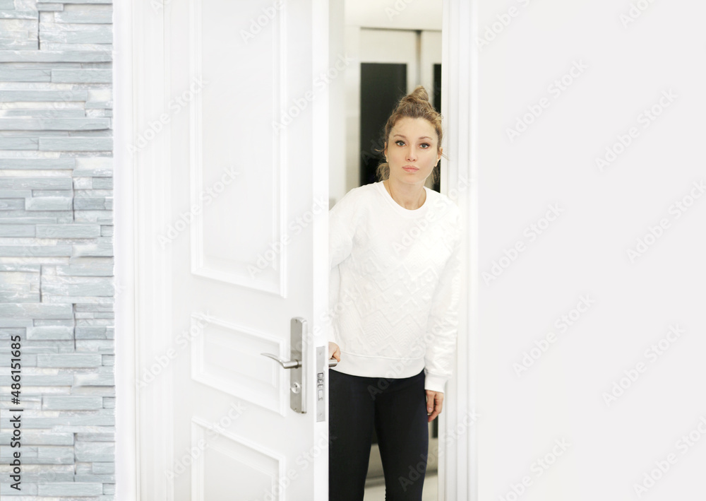 Beautiful woman opening the door of her home. Beautiful woman opening the door of her home.