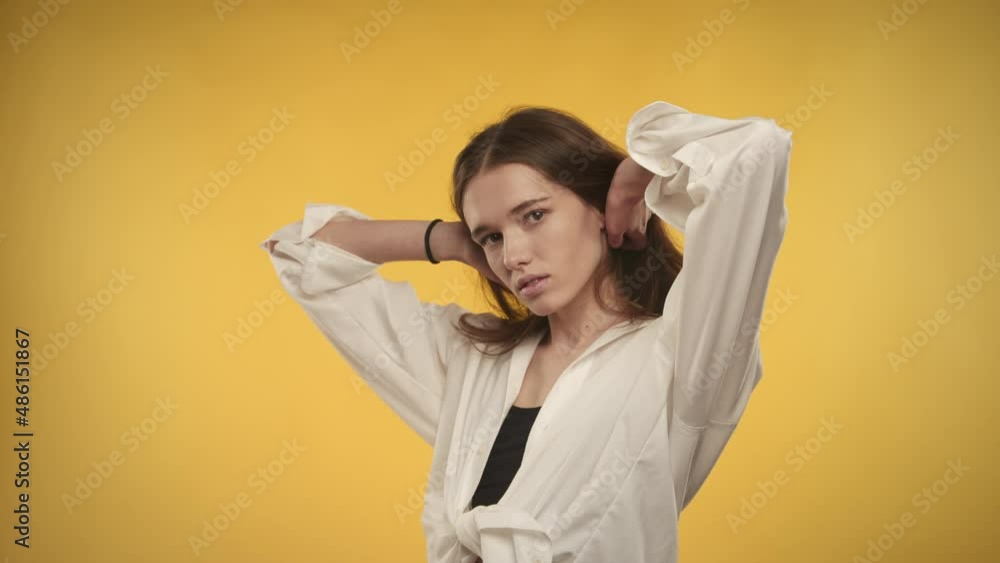 Portrait of a 20s caucasian woman smiling at camera on a bright yellow background Portrait of a 20s caucasian woman smiling at camera on a bright yellow background