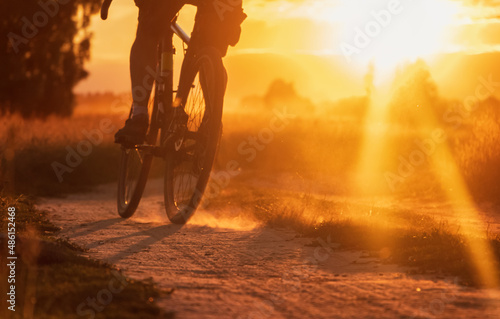 Photos Silhouette of a cyclist on a gravel bike riding a countryside trail at sunset
