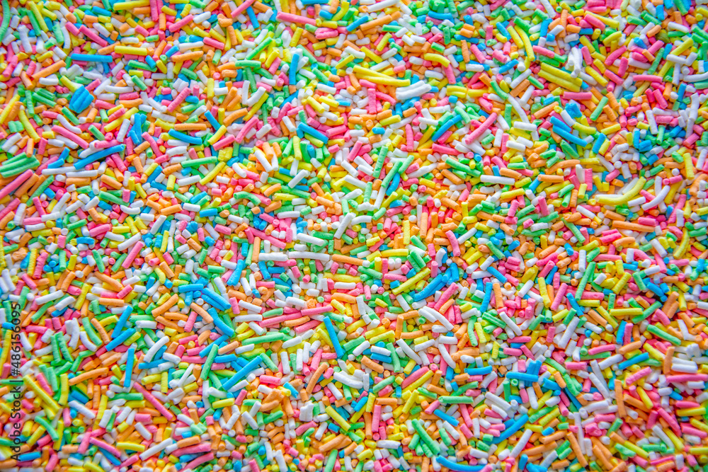 Background covered with small cake decorations of different colors