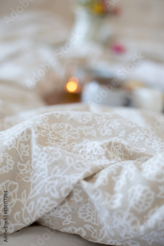 A cozy breakfast in bed set up with coffee, candle, & neutral setup