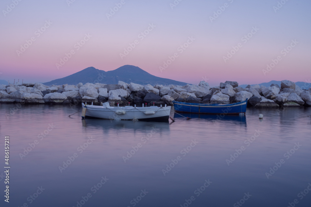 Boats are docked in Naples port, in backgroud is standing out Vesuvius 