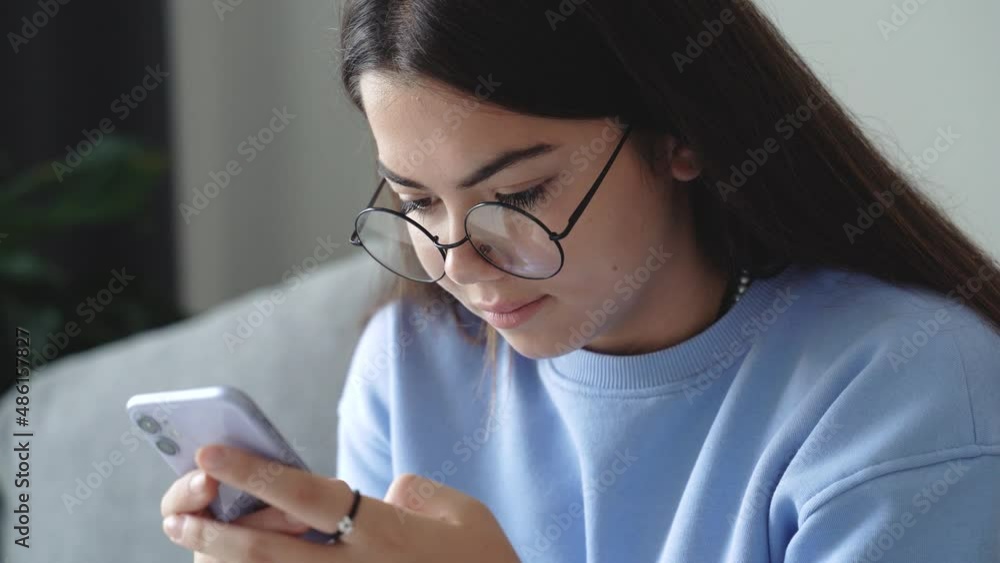 Happy teenage girl school pupil holding mobile phone. Teenager's hands typing, scrolling, searching browsing chatting send sms, studying at home. Social media concept. 4k footage Happy teenage girl school pupil holding mobile phone. Teenager's hands typing, scrolling, searching browsing chatting send sms, studying at home. Social media concept. 4k footage