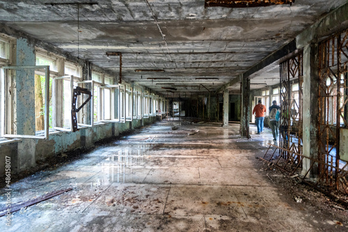 Tourists walking through an abandoned school in Pripyat, Ukraine near the Chernobyl nuclear disaster of 1986.