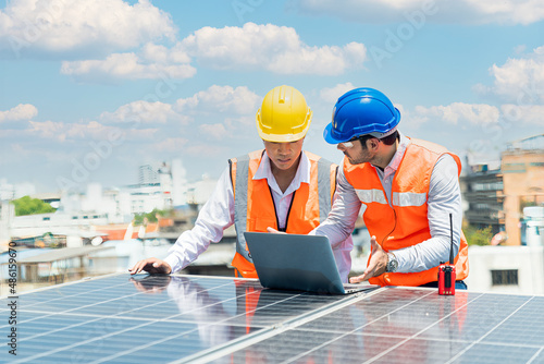 A technician or electrical engineer is teaching an apprentice to work. Foreman and Worker maintaining solar energy panel. photo