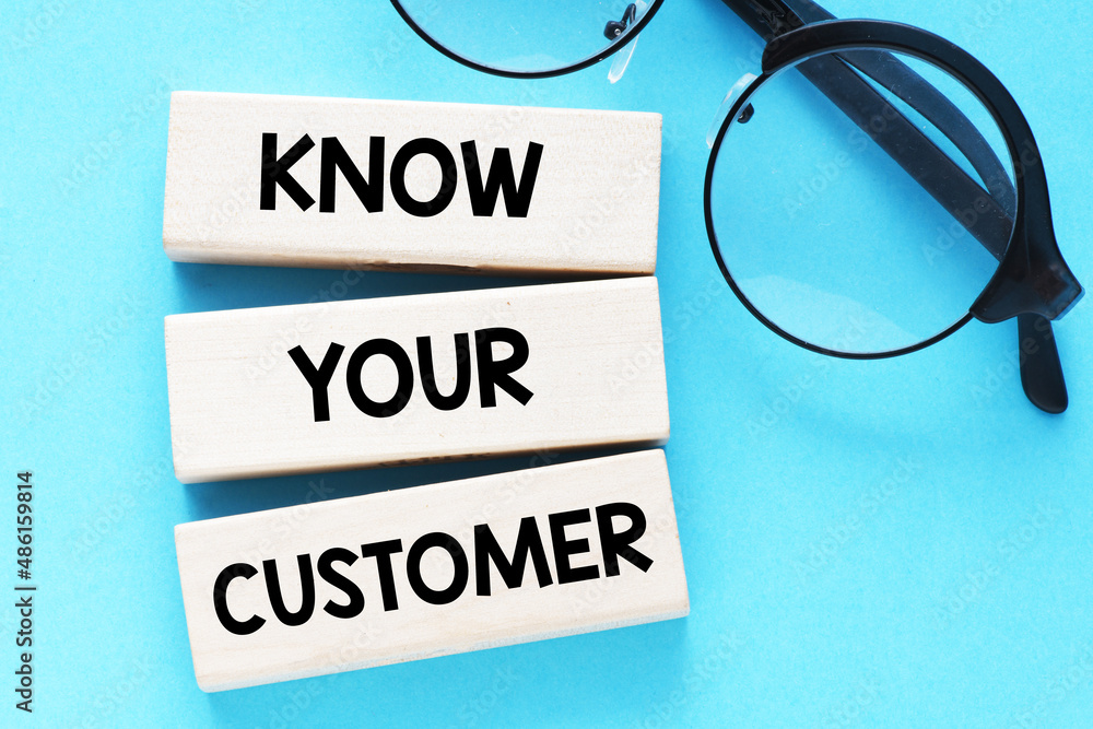 KNOW YOUR CUSTOMER words on wooden blocks and a blue background. KNOW YOUR CUSTOMER words on wooden blocks and a blue background.
