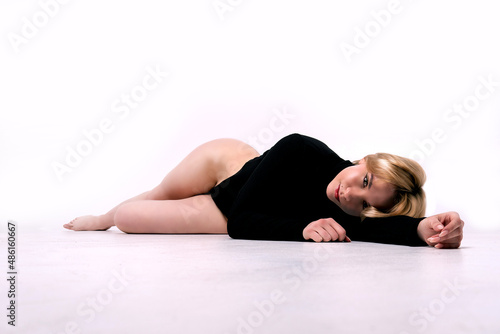 Beautiful girl lies on a white isolated background in a black swimsuit red hair model sensual hygiene health, for beautiful isolated in girl and beauty bare, natural fashion. White glamour background