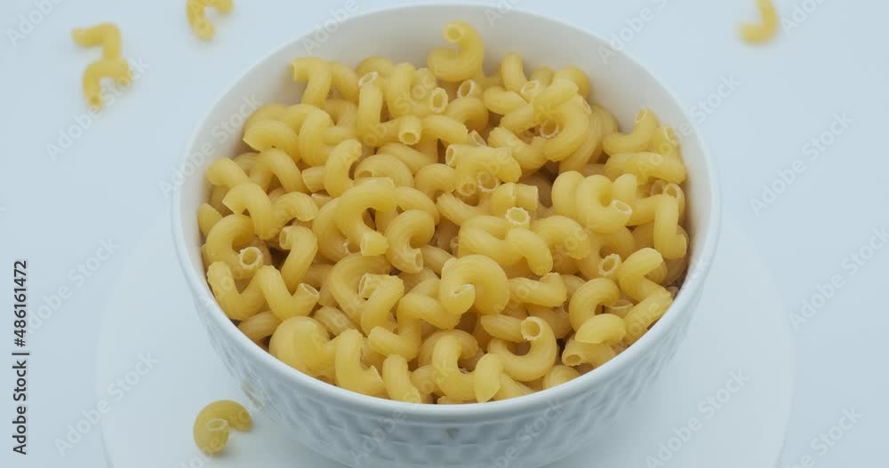 Pasta falling into white bowl on white background Pasta falling into white bowl on white background