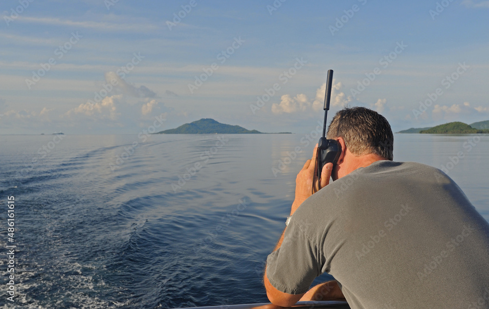 Fotografie Man using satellite phone at sea.