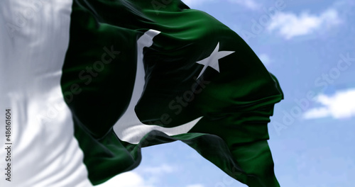 Detail of the national flag of Pakistan waving in the wind on a clear day.