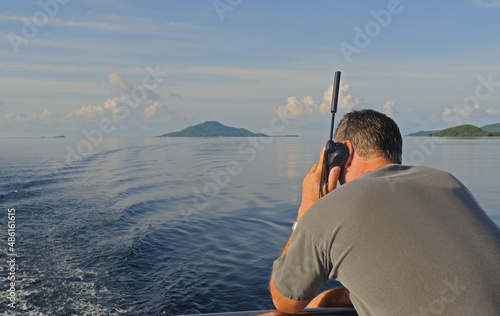 Man using satellite phone at sea. photo