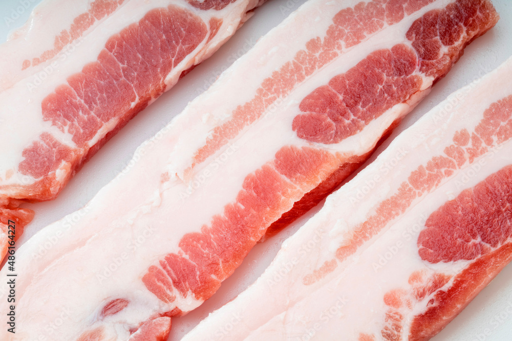 Streaky pork on white background, Close up cutting slide pork belly raw or streaky pork on white background. Streaky pork on white background, Close up cutting slide pork belly raw or streaky pork on white background.