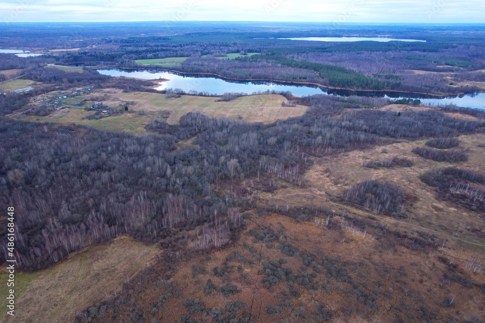 Lake in autumn season. Aerial panoramic landscape view of lake in village of Staroselye, Chashniki region, Belarus. Drone view of lake in spring. Aerial view of wetland in fall colors..