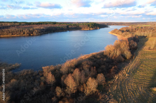 Lake on sunset in autumn season. Aerial panoramic landscape view of lake in village of Staroselye, Chashniki region, Belarus. Drone view of lake in spring. Aerial view of wetland in fall colors..