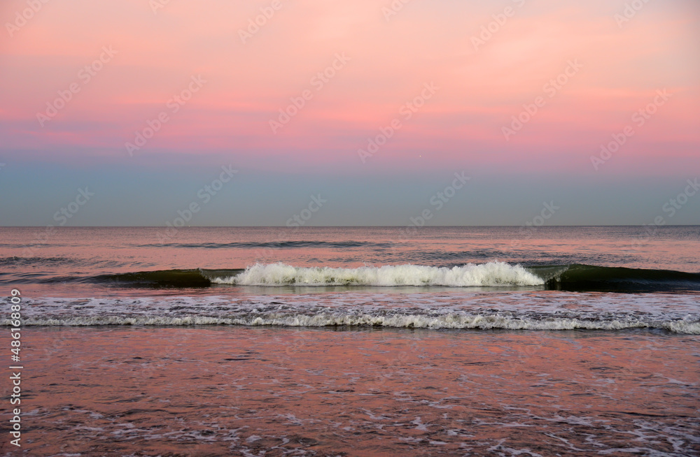 Waves at sea on dramatic sunset background. Waves at sea during storm and wind. Wave from the sea goes on land to the beach. Splashing Waves in ocean, background, texture. Wave at Rising Storm. Waves at sea on dramatic sunset background. Waves at sea during storm and wind. Wave from the sea goes on land to the beach. Splashing Waves in ocean, background, texture. Wave at Rising Storm.